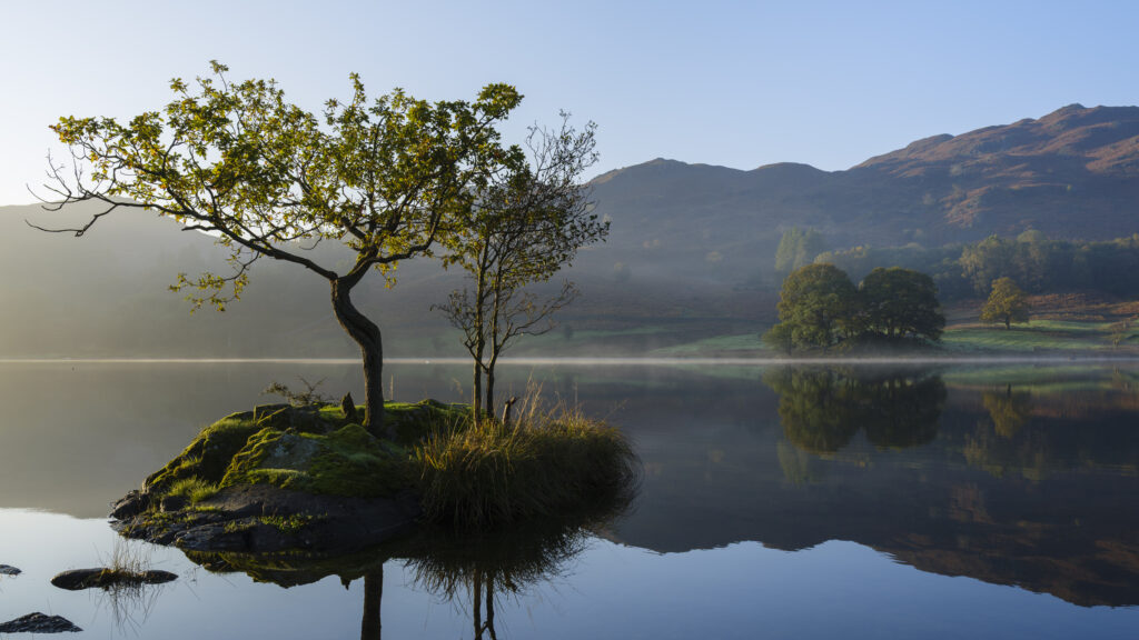 England, Cumbria, Lake District National Park. Early morning reflections at Rydal Water, on a still autumn day.