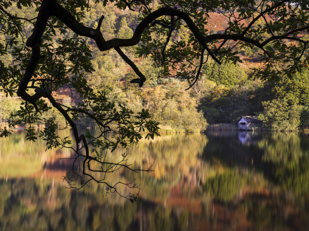 England, Cumbria, Lake District National Park. Early morning reflections at Rydal Water, on a still autumn day.