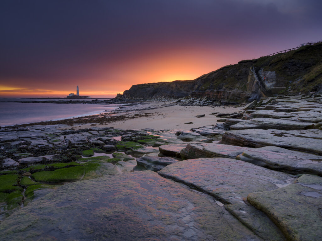 England, Northumberland, Old Hartley. Old Hartley Bay at dawn, looking towards St Mary's Lighthouse.