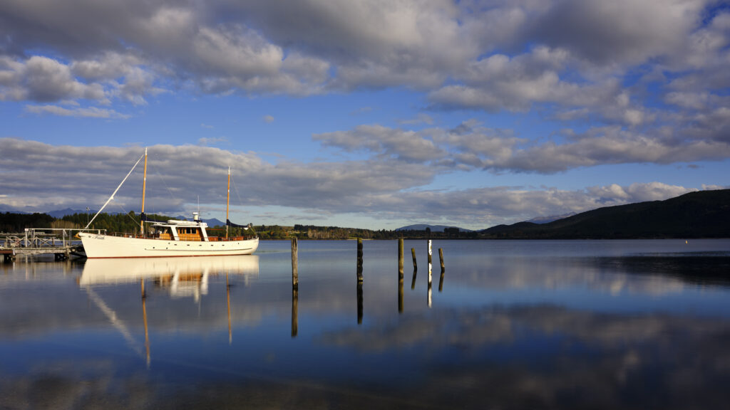 New Zealand, South Island, Fiordland National Park. Yacht moored near a jetty on Lake Te Anau - Gateway to Fiordland National Park.