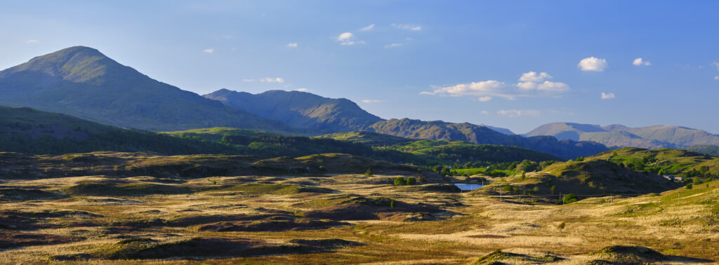 England, Cumbria, Lake District National Park. Panoramic view looking across Torver Common towards the Old Man of Conistion and surrounding mountains and fells.