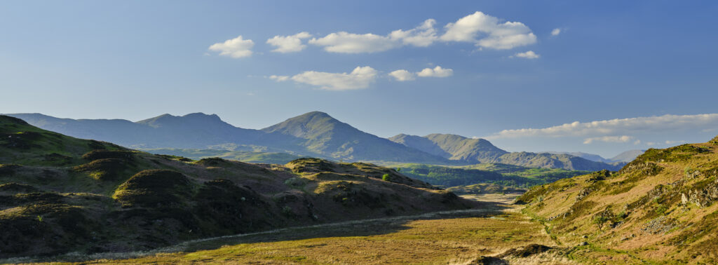 England, Cumbria, Lake District National Park. Panoramic view looking across Torver Common towards the Old Man of Conistion and surrounding mountains and fells.