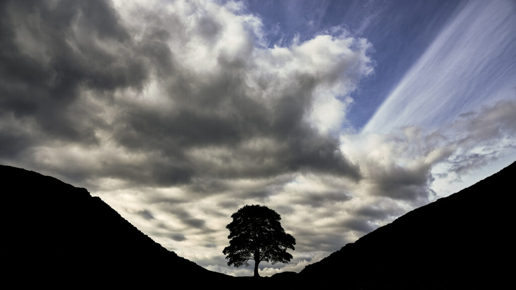 England, Northumberland, Hadrian's Wall. Storm clouds above Sycamore Gap, a famous landmark along Hadrian's Wall.