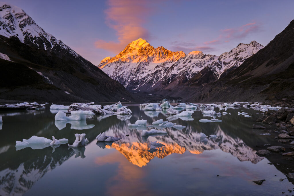 New Zealand, South Island, Aoraki / Mount Cook National Park. Mount Cook, New Zealands highest mounatin, and the Southern Alps viewed from the iceberg speckled Hooker Lake.