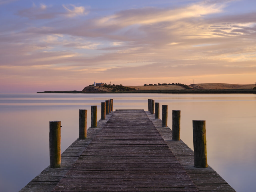 Australia, Southern Australia, Narrung Jetty Reserve. The Narrung Jetty looking across the Lake Alexandrina Narrows towards the Point Malcolm Lighthouse.