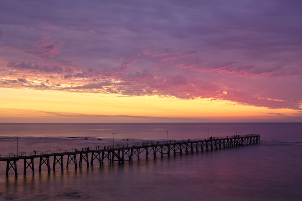 Australia, South Australia, Port Noarlunga. A colourful sunset and Port Noarlung Pier.