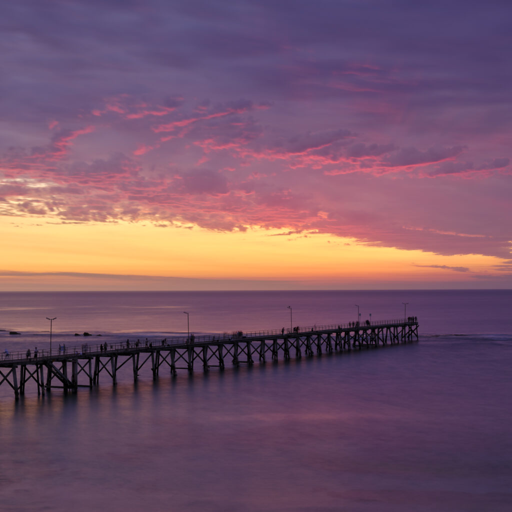 Australia, South Australia, Port Noarlunga. A colourful sunset and Port Noarlung Pier.
