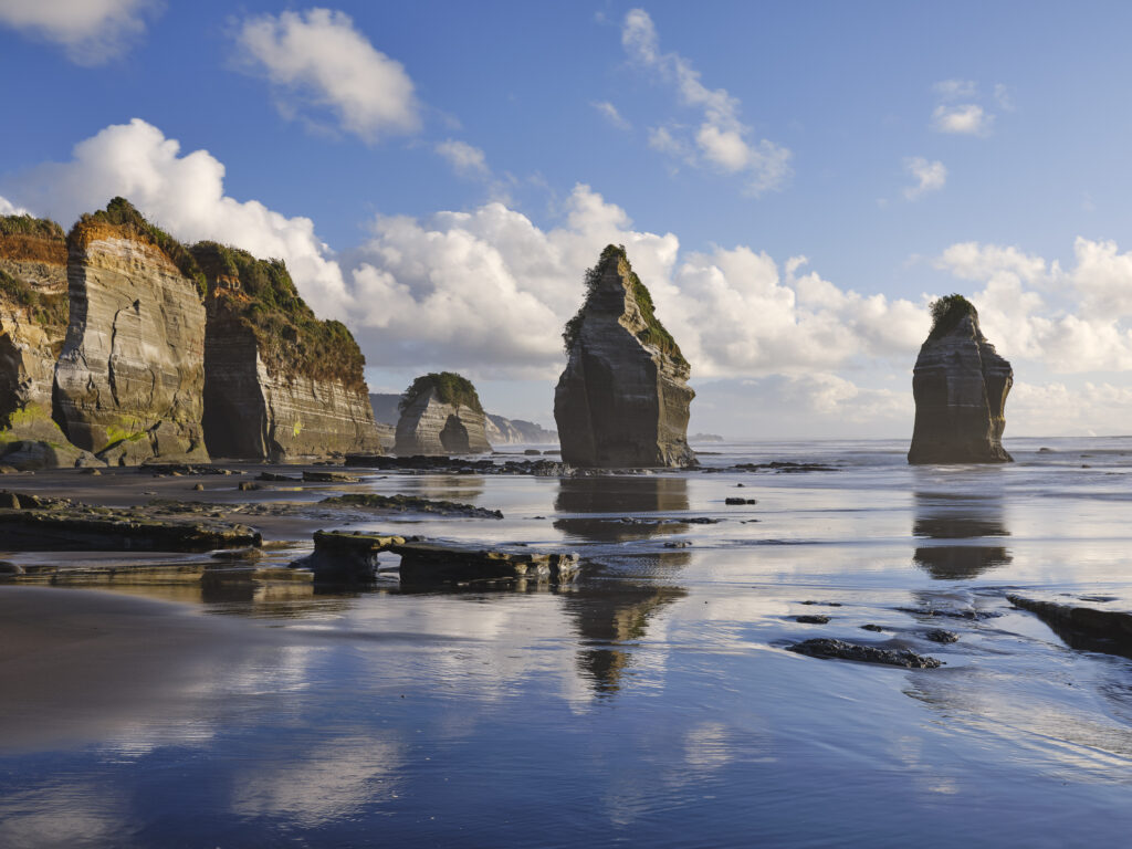 New Zealand, North Island, Three Sisters. The unique rock formations known as the Three Sisters and The Elephant, located on the North Taranaki Coast near Tongaporutu.