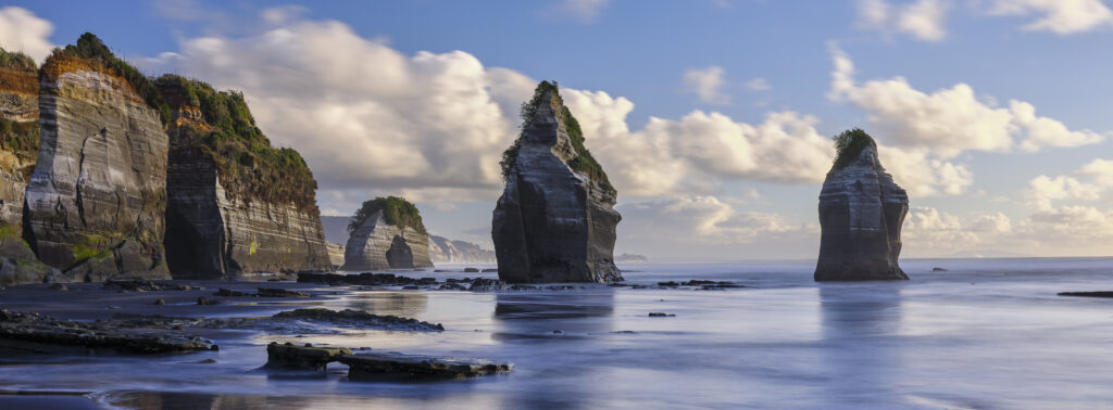 New Zealand, North Island, Three Sisters. The unique rock formations known as the Three Sisters and The Elephant, located on the North Taranaki Coast near Tongaporutu.