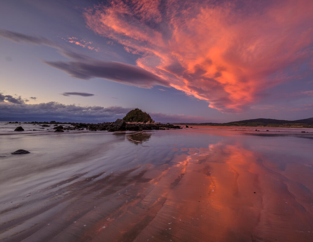 New Zealand, Southland, Monkey Island. A colourful sunset viewed from Te Waewae Bay looking towards Monkey Island.