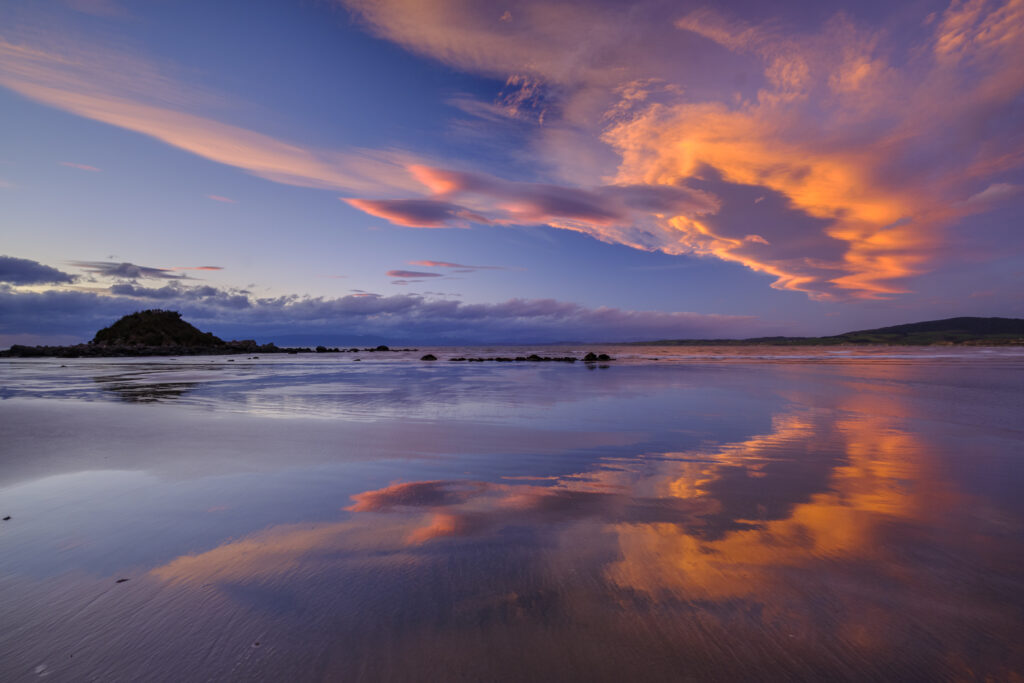 New Zealand, Southland, Monkey Island. A colourful sunset viewed from Te Waewae Bay looking towards Monkey Island.