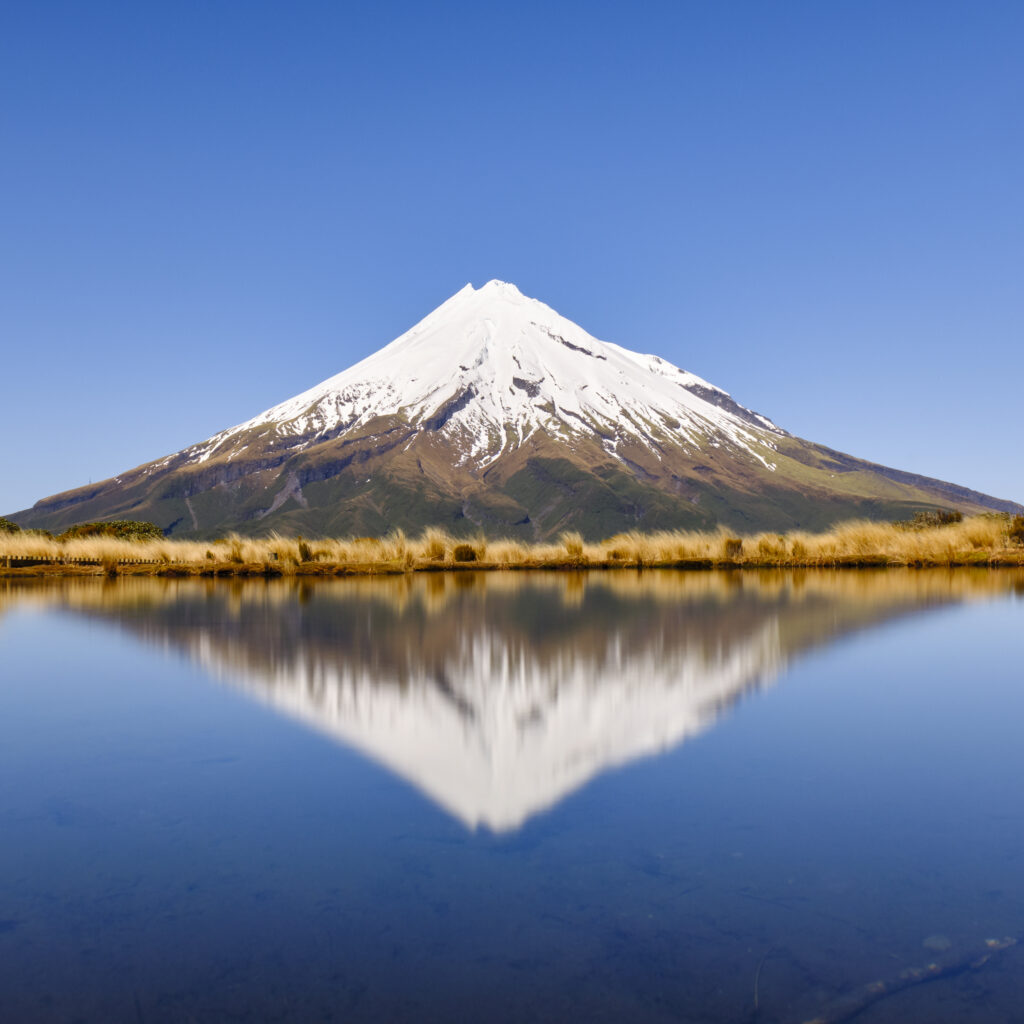 New Zealand, North Island, Egmont National Park. The iconic Taranaki stratovolcano (Mt Egmont) reflected in the still waters of the Pouakai Tarn.