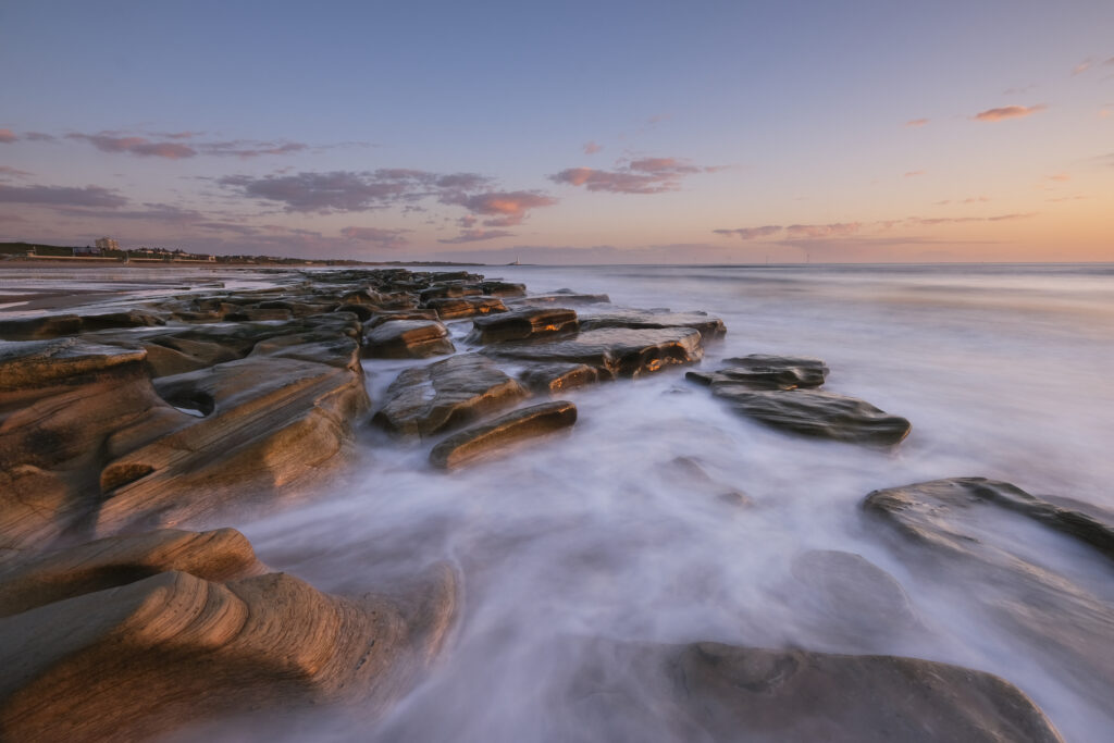Low tide reveals the rocky coastline of Whitley Sands.