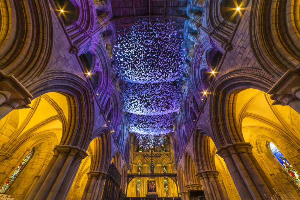 England, Northumberland, Hexham Abbey. 'On Angel Wings', an ariel installation of origami paper angels to mark the covid 19 pandemic located in the chancel of Hexham Abbey in Northumberland.