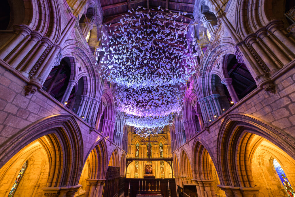 England, Northumberland, Hexham Abbey. 'On Angel Wings', an ariel installation of origami paper angels to mark the covid 19 pandemic located in the chancel of Hexham Abbey in Northumberland.