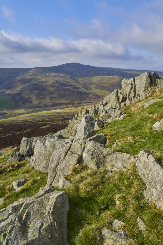 England, Northumberland National Park, Harthope Valley. Breaking light at Housey Crags located above the Harthope Valley.