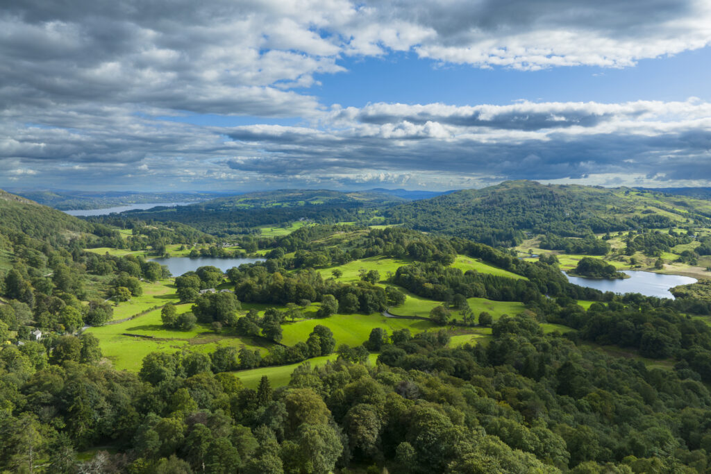 England, Cumbria, Lake District National Park. Aerial view of Elterwater, Loughrigg Tarn and Lake Windermere looking south towards the southern lake district.