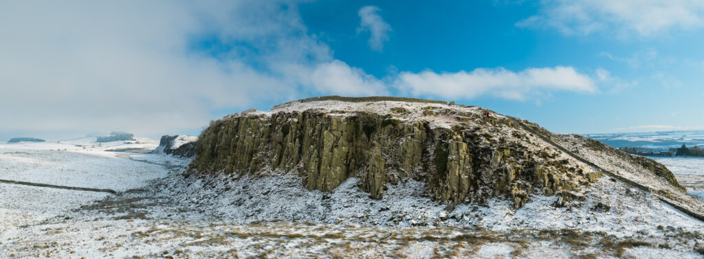 England, Northumberland National Park, Hadrian's Wall. Hadrian's Wall snaking over the crags of Steel Rigg with Crag Lough in the distance.