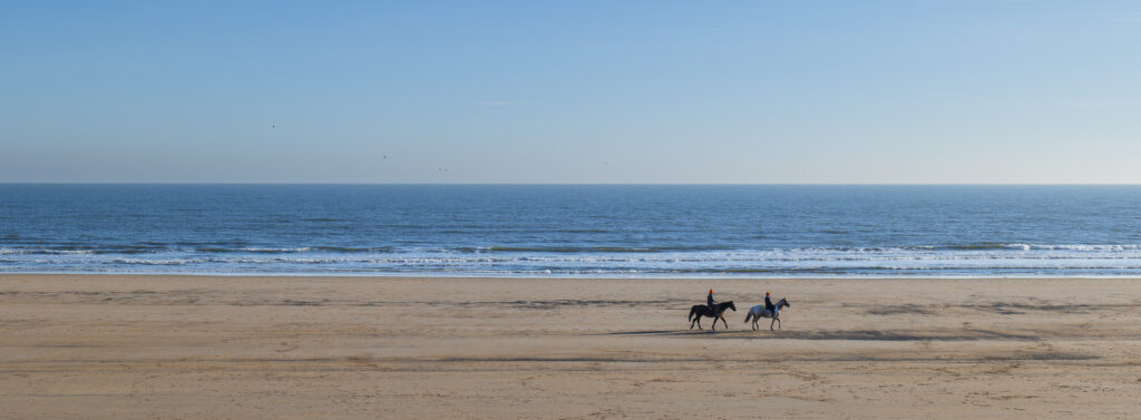England, Northumberland, Druridge Bay. Horse riders on the picturesque sandy beach at Druridge Bay.