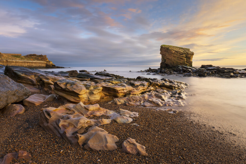 England, Northumberland, Seaton Sluice. Sunrise at Charlies Garden, a rock formation located in Collywell Bay, Seaton Sluice.