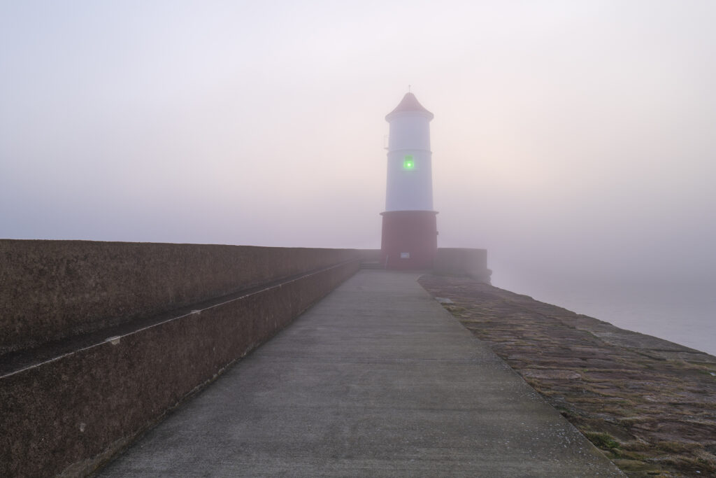 England, Northumberland, Berwick Upon Tweed. A misty morning at Berwick Upon Tweed, with the lighthouse and pier surrounded in fog.