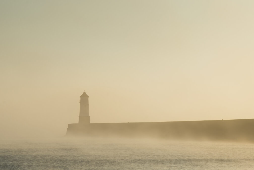 England, Northumberland, Berwick Upon Tweed. A misty morning at Berwick Upon Tweed, with the lighthouse and pier surrounded in fog.