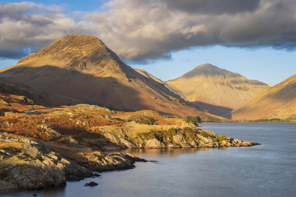 England, Cumbria, Lake District National Park. Evening light illuminates Great Gable and the other mountains surrouding Wasdale, viewed from Wastwater - The deepest lake in England.