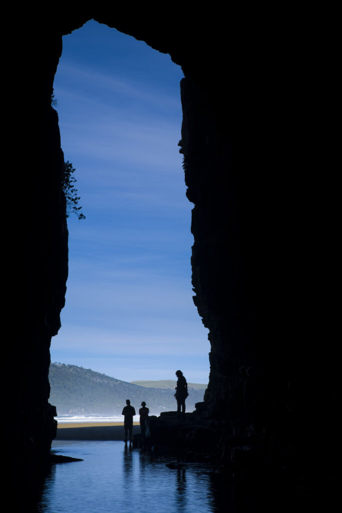 New Zealand, Southland, The Catlins. Tourists admiring the Cathedral caves.