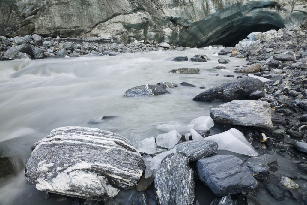 NEW ZEALAND, Westland, Westland National Park. Glacial river and glacial deposited rocks downstream of the Franz Josef Glacier.