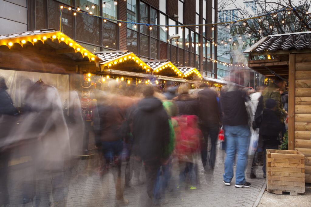 England, Greater Manchester, Brazennose Street Christmas Market. Busy street market with visiting shoppers enjoying the xmas stalls.