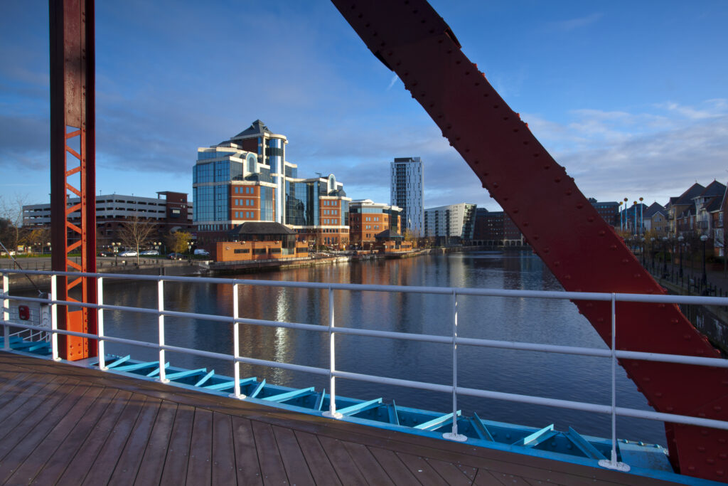 England, Greater Manchester, Salford Quays. Victoria Harbour building viewed from Detroit footbridge on the Manchester Ship Canal located in Salford.