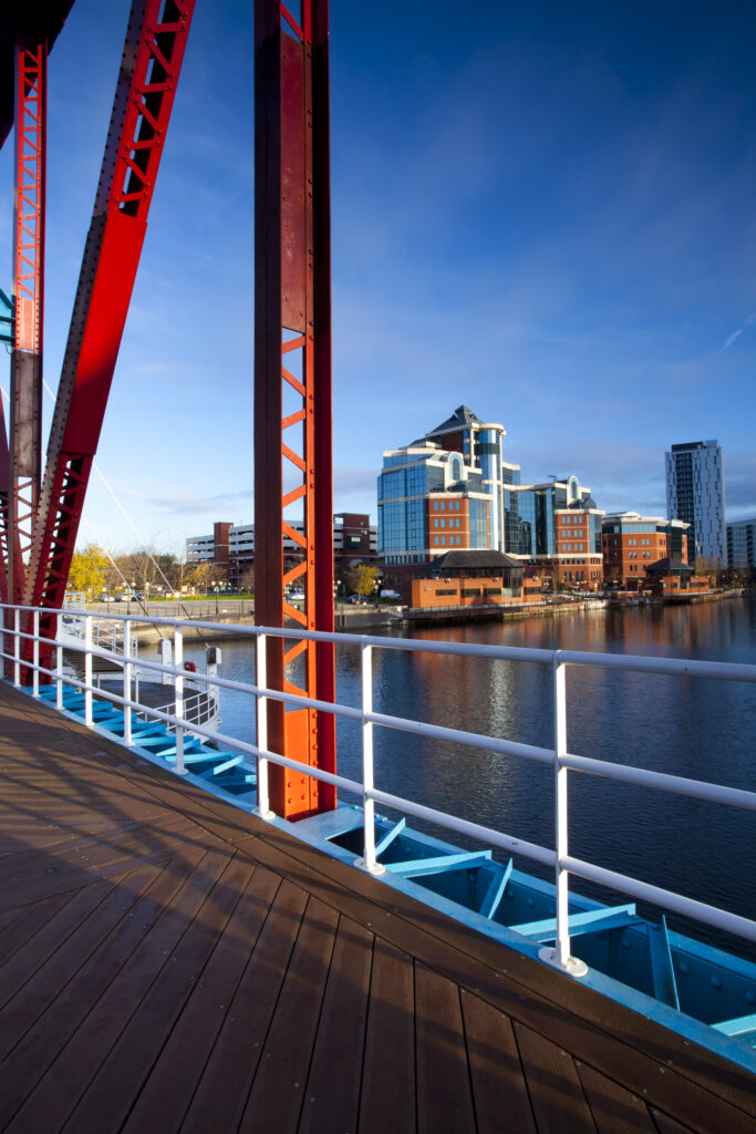 England, Greater Manchester, Salford Quays. Victoria Harbour building viewed from Detroit footbridge on the Manchester Ship Canal located in Salford.