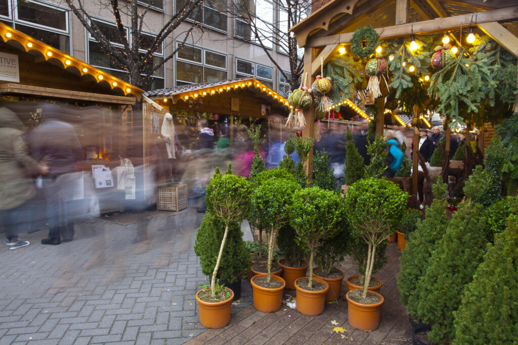 England, Greater Manchester, Brazennose Street Christmas Market. Busy street market with visiting shoppers enjoying the xmas stalls.