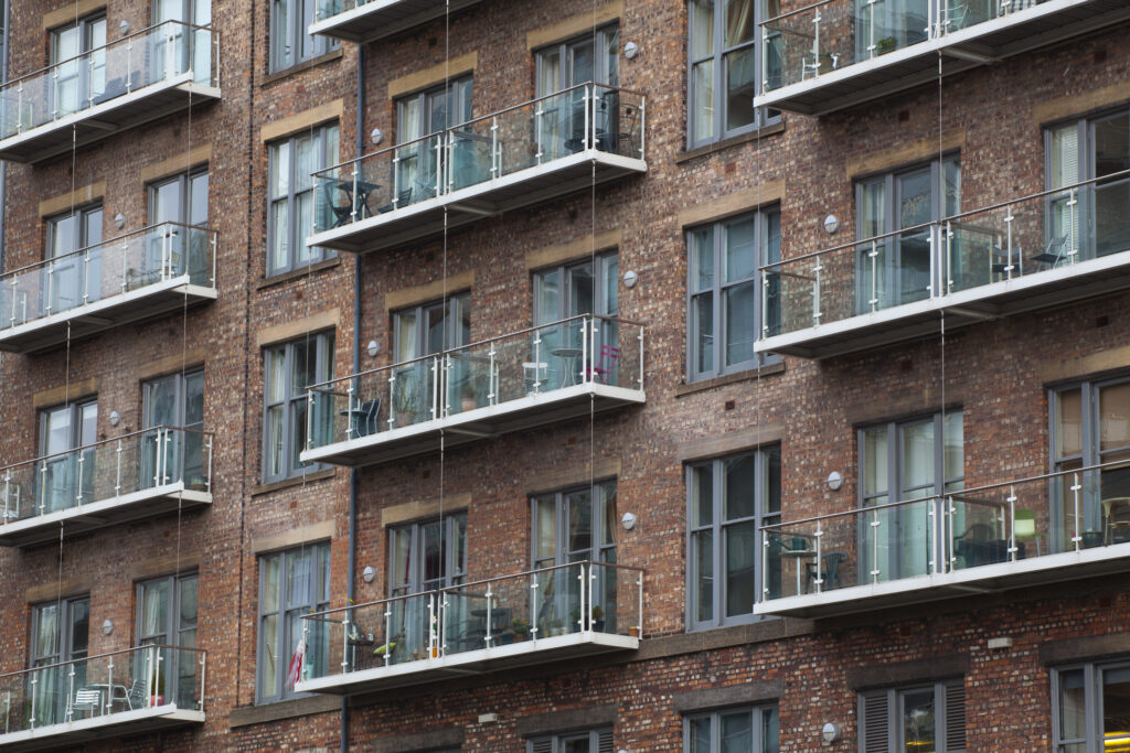England, Greater Manchester, Manchester. Detail shot of modern apartments formed by redevolping Victorian warehouses located on the banks of the River Irwell near the Trinity Bridge.