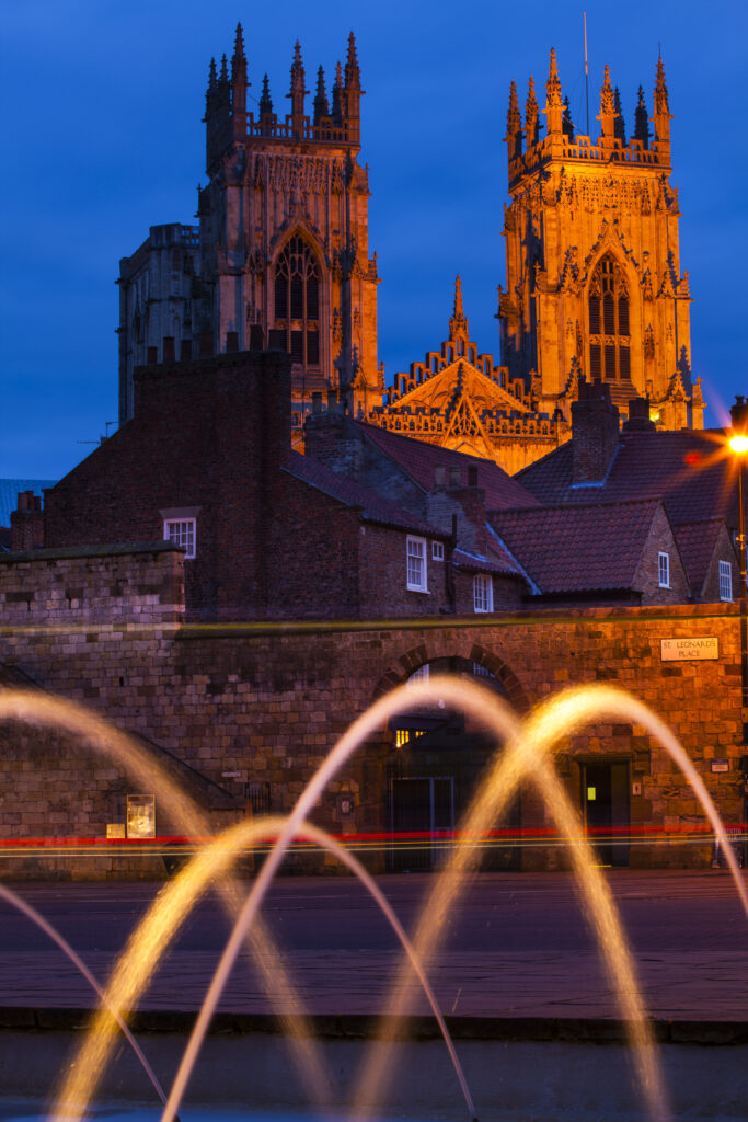 England, North Yorkshire, York City. The west front of the york minster cathedral ovelooking the city walls, viewed from fountains in the city art gallery.