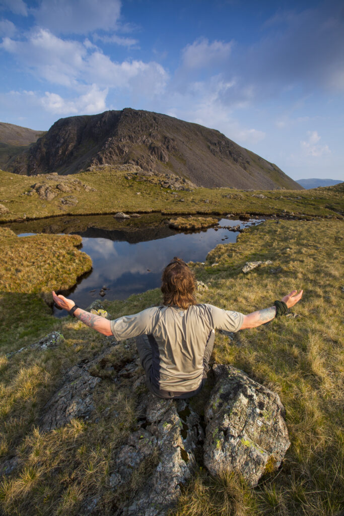 England, Cumbria, Lake District National Park. Man in his early 40's admiring the mountain peaks of the north western district of the Lake District National Park.