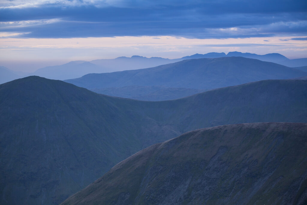 England, Cumbria, Lake District National Park. Mountain fog in the valleys of the western Lake District overlooked by the highest peak, Scafell Pike.