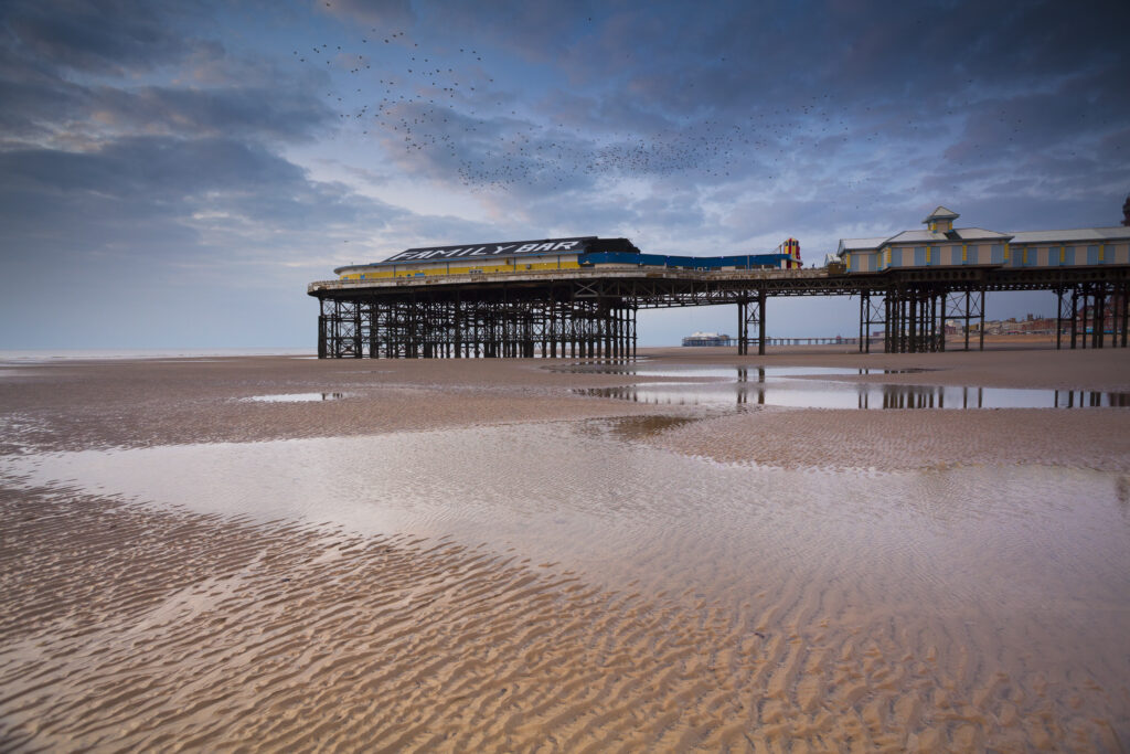 England, Lancashire, Blackpool. A flock of starlings above the Family Bar on Blackpool Central Pier located in the popular northern England seaside resort.