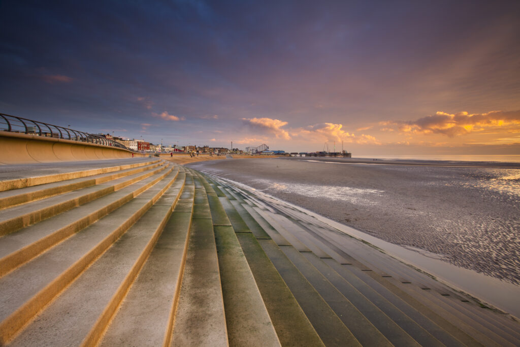 England, Lancashire, Blackpool. Blackpool Seafront Steps and Sea Defenses looking towards the South Pier and the Pleasure Beach.