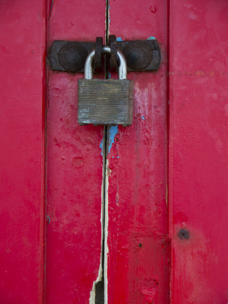 England, North Yorkshire, Scarborough. Padlock on the doors of colourful beach huts located on Scarborough South Bay.