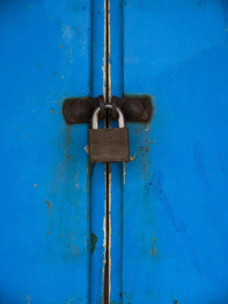 England, North Yorkshire, Scarborough. Padlock on the doors of colourful beach huts located on Scarborough South Bay.