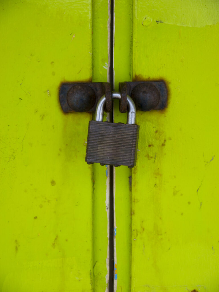 England, North Yorkshire, Scarborough. Padlock on the doors of colourful beach huts located on Scarborough South Bay.