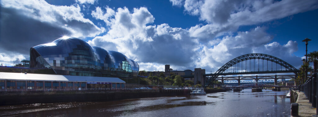 England, Tyne and Wear, Newcastle Upon Tyne. The Sage Building and world-famous Tyne Bridge, crossing the Newcastle Upon Tyne and Gateshead Quayside.
