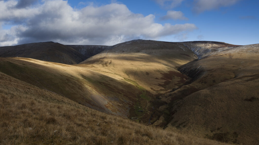 England, Northumberland, Northumberland National Park. Fleeting light on Auchope Rig and the Cheviot, with the distinct form of the Hen Hole.