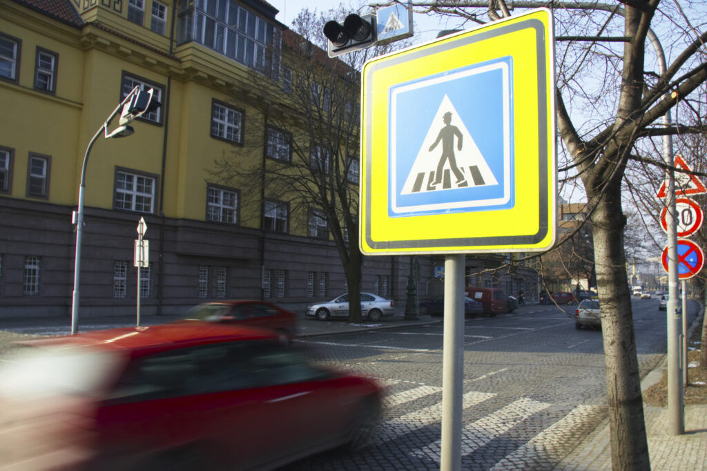 Czech Republic, Prague, Prague City. A red car speeds over a pedestrian crossing in Prague City.