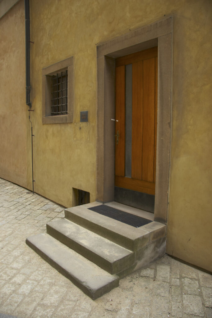 Czech Republic, Prague, Prague Castle. A rustic door and steps on a building forming part of Prague Castle in the city of Prague