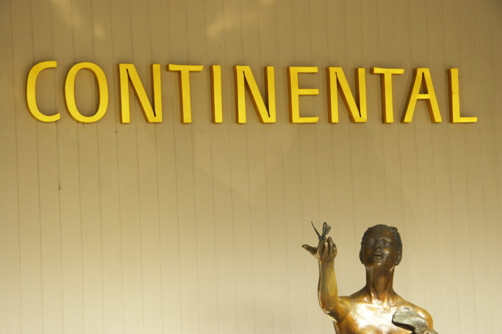 Czech Republic, Prague, Prague City.Continental wrote above a gold coloured statue at a hotel in Prague.