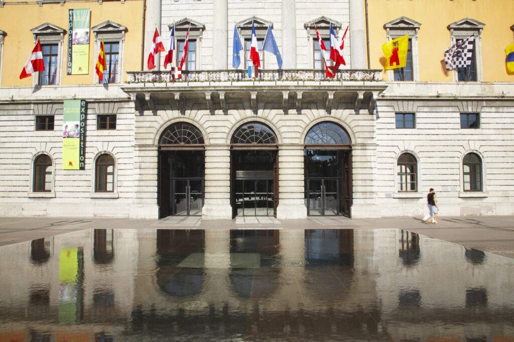 France, Rhône-Alpes, Annecy The colourful Annecy Town Hall (Ville d Annecy) relected in a water feature outside the building