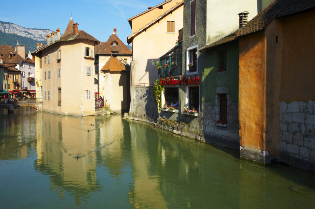 France, Rhône-Alpes, Annecy Rustic buildings reflected in the Thiou Canal running through the heart of the town of Annecy