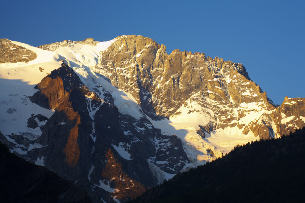 France, Rhône-Alpes, The Ecrins National Park. Morning light illuminates the peak of Le Rateau, within the Ecrins National Park near the village of La Grave.